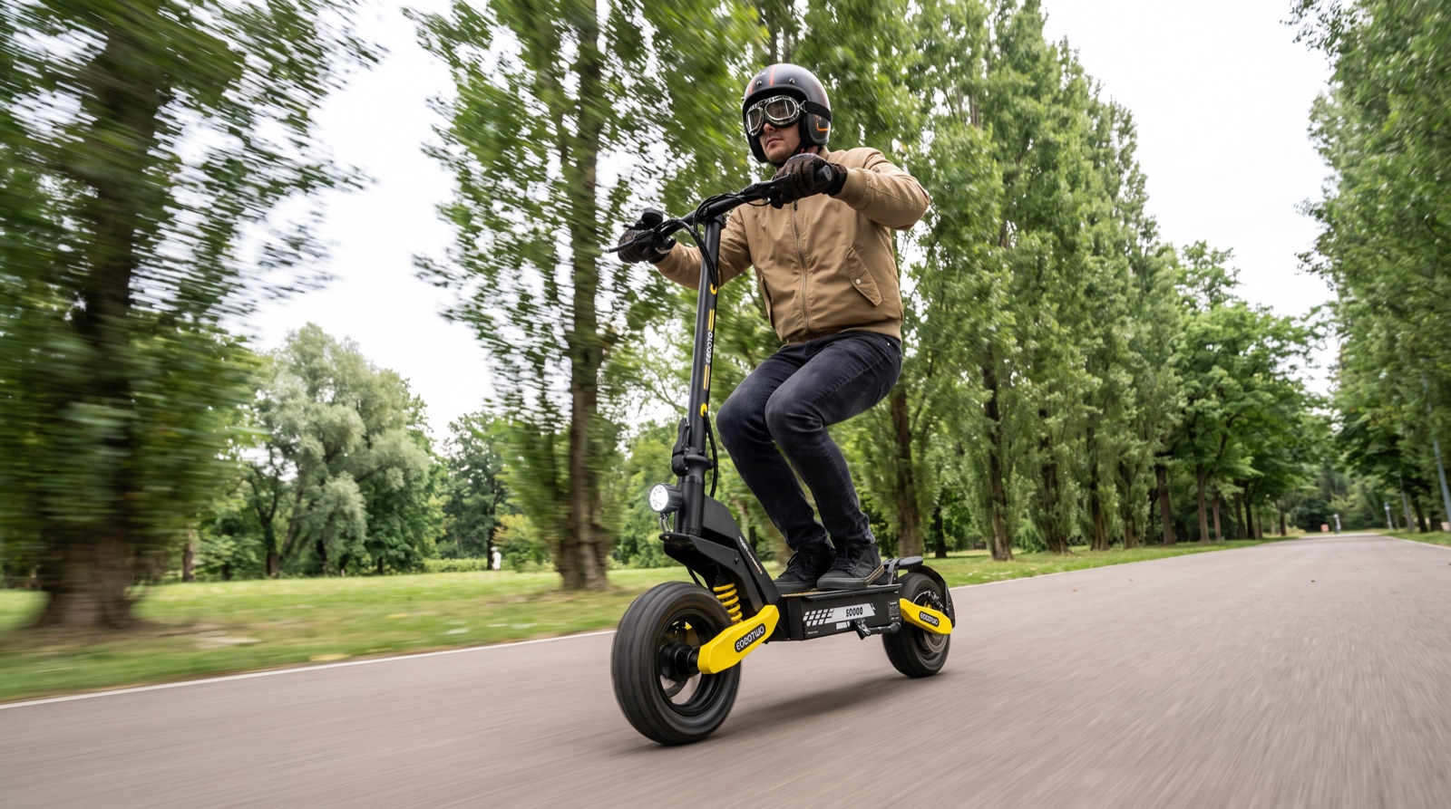 Rider on the scooter along a paved park trail